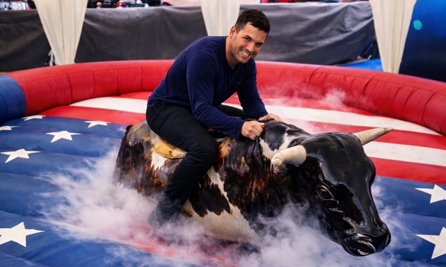 Persona montando un toro mecánico.