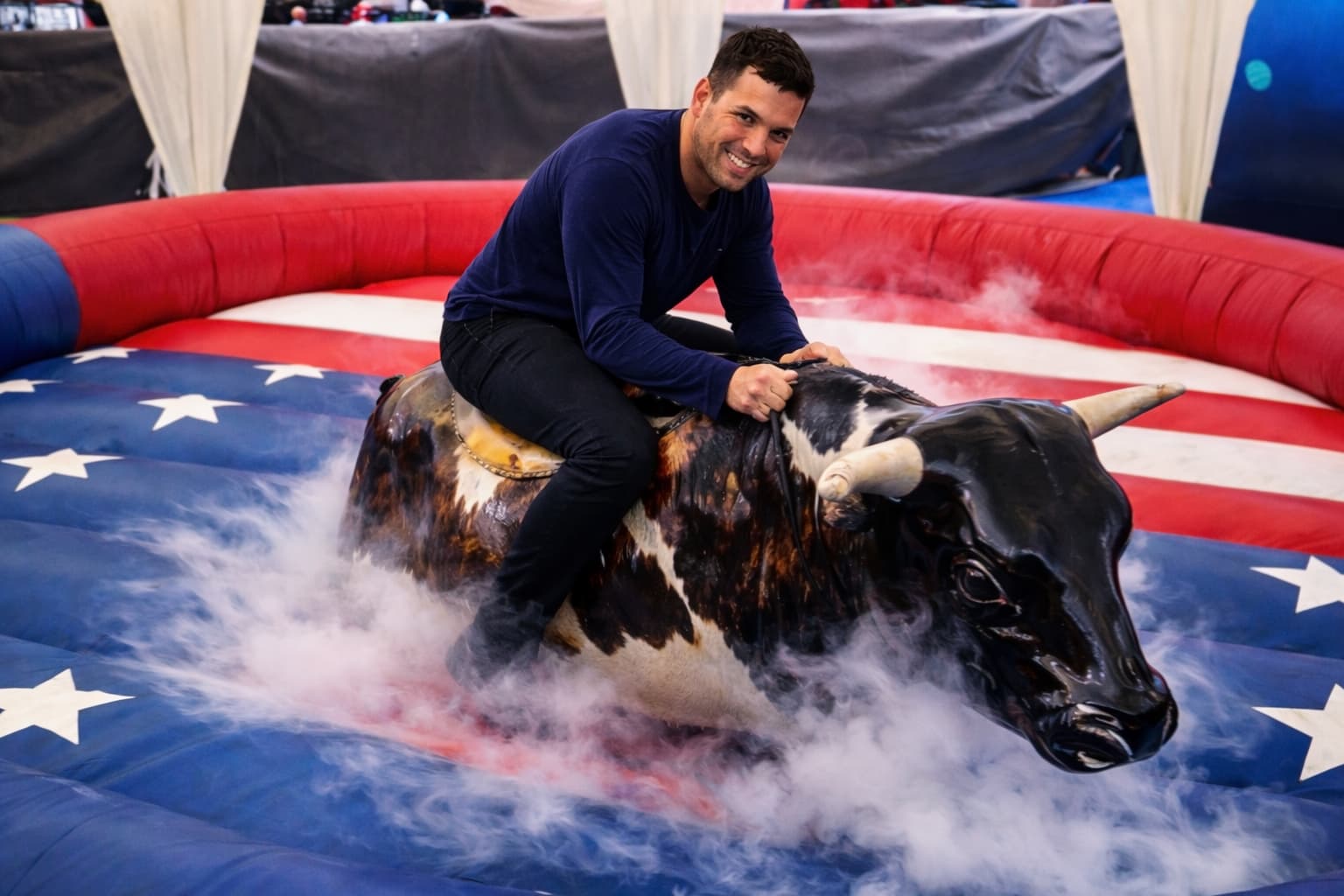 Persona montando un toro mecánico.