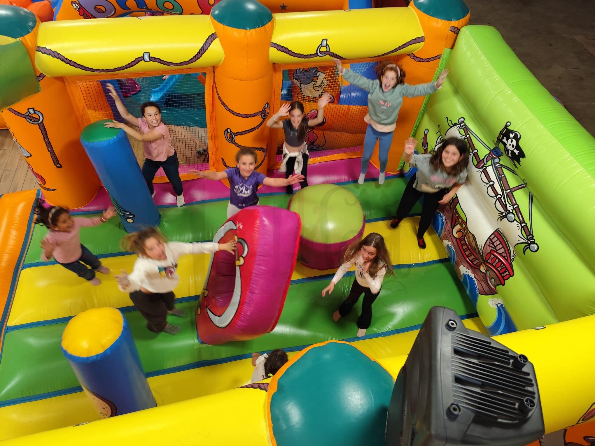 niños jugando en castillo hinchable durante actividades infantiles en evento fallero