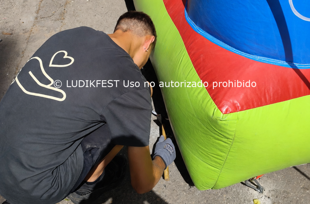 Monitor de Ludikfest realizando instalación y anclaje de un hinchable con medidas de seguridad