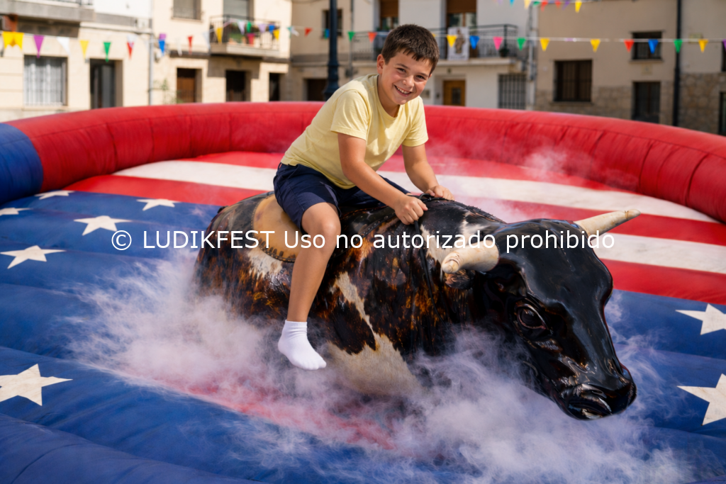 Niño participando en una actividad de toro mecánico de LUDIKFEST