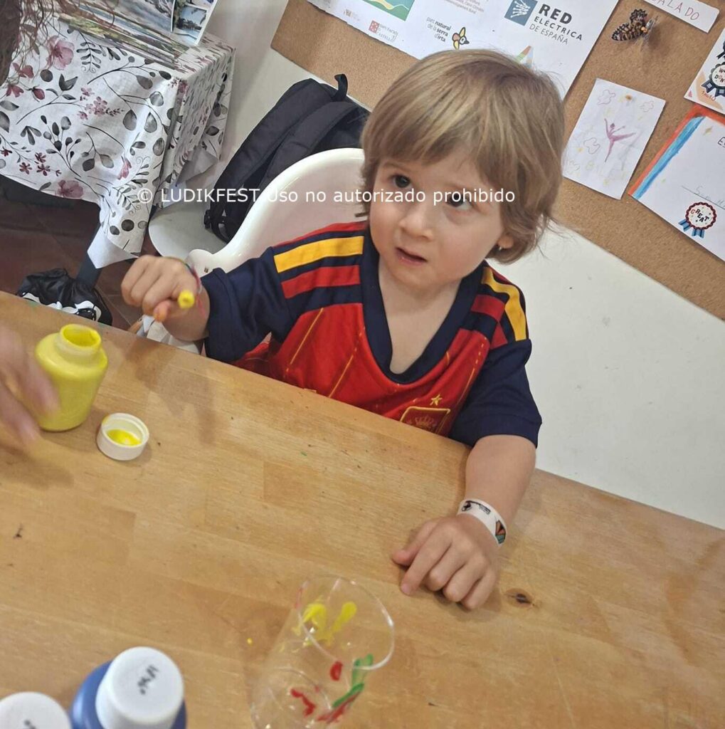 Niño con mutación genética CTBP1 realizando una actividad de motricidad fina durante un taller de ocio educativo inclusivo.