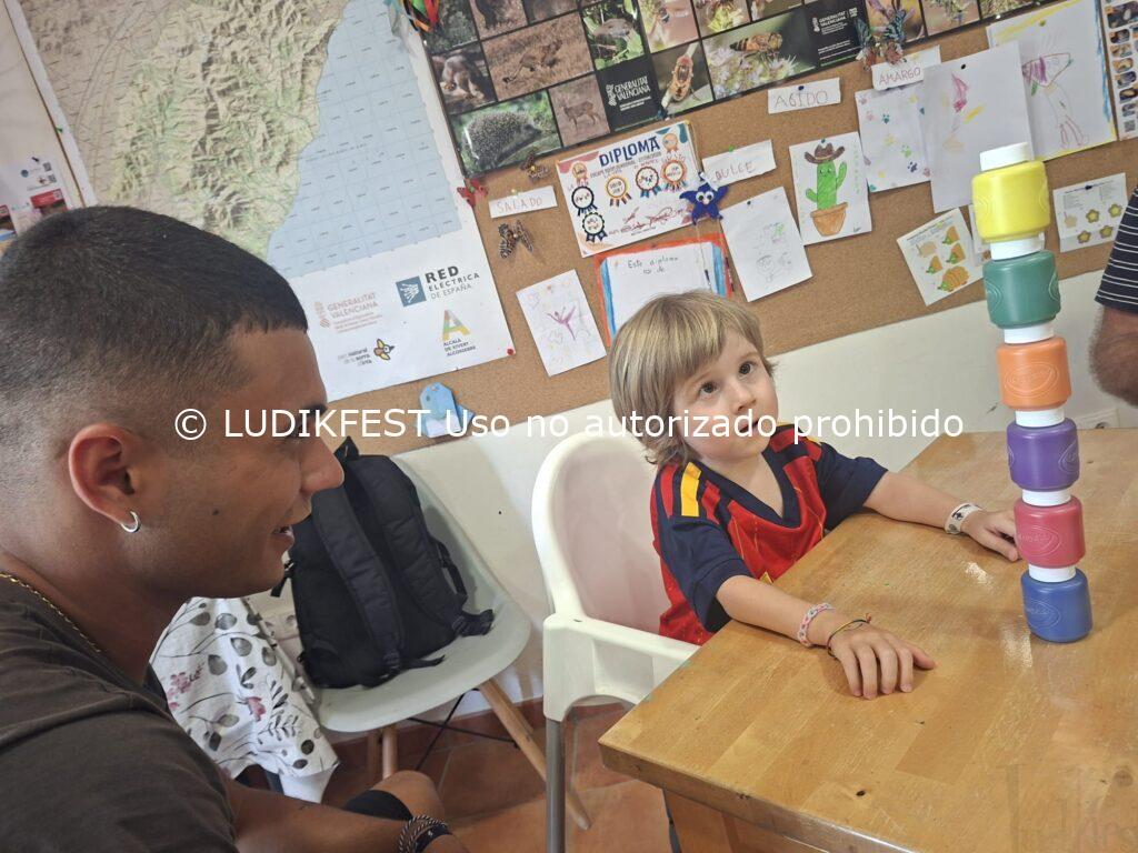 Enric, niño con mutación genética CTBP1, participando en una actividad de ocio educativo inclusivo junto a un monitor de LUDIKFEST.
