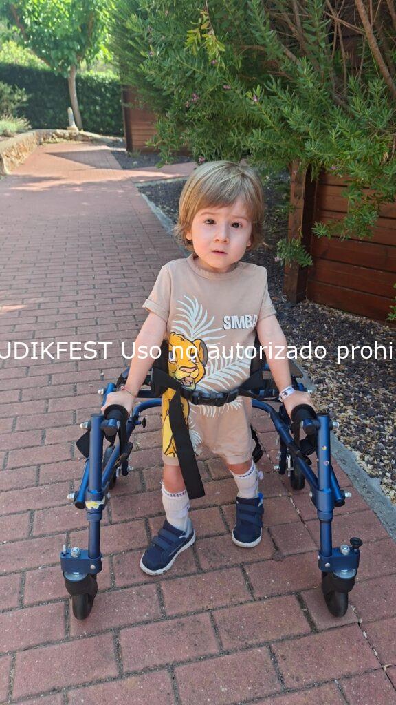 Enric, niño con mutación genética CTBP1, caminando con su andador durante unas vacaciones en el Camping Ribamar de Alcossebre.